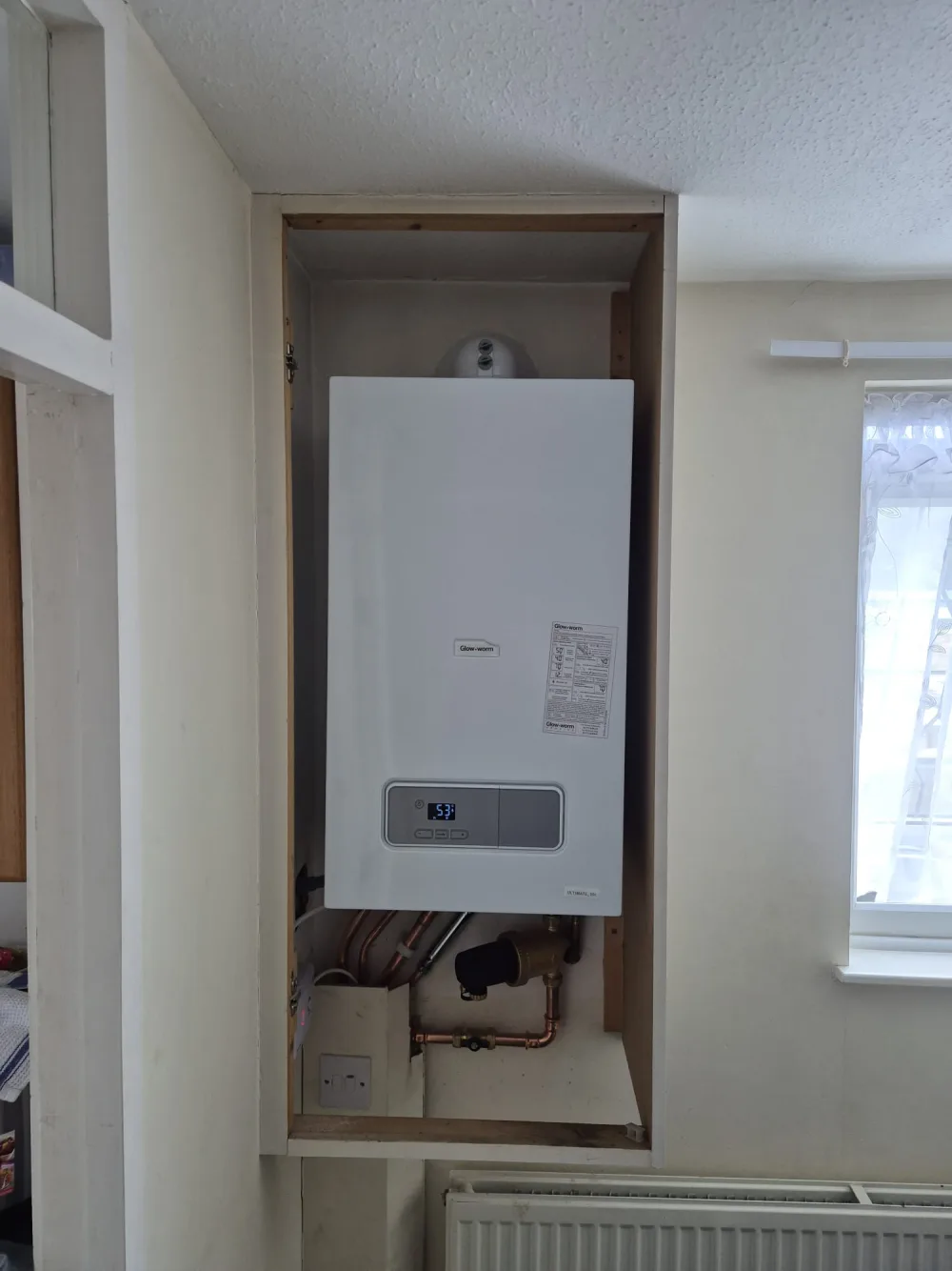 Wall-mounted domestic boiler in a tall cupboard