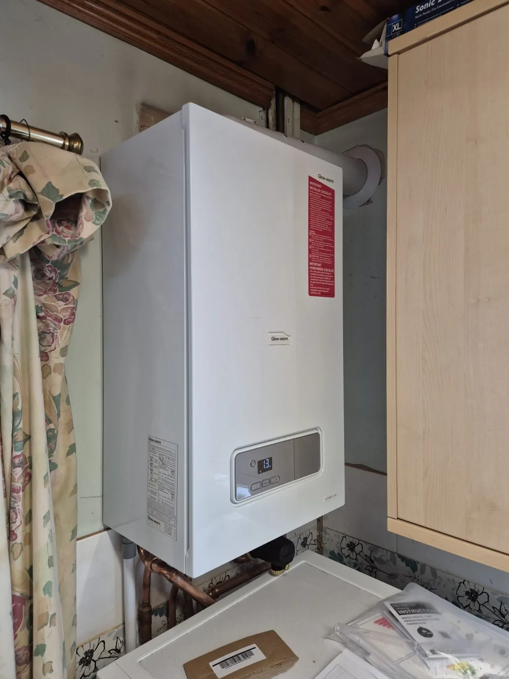 Wall-mounted domestic boiler installed in a cupboard