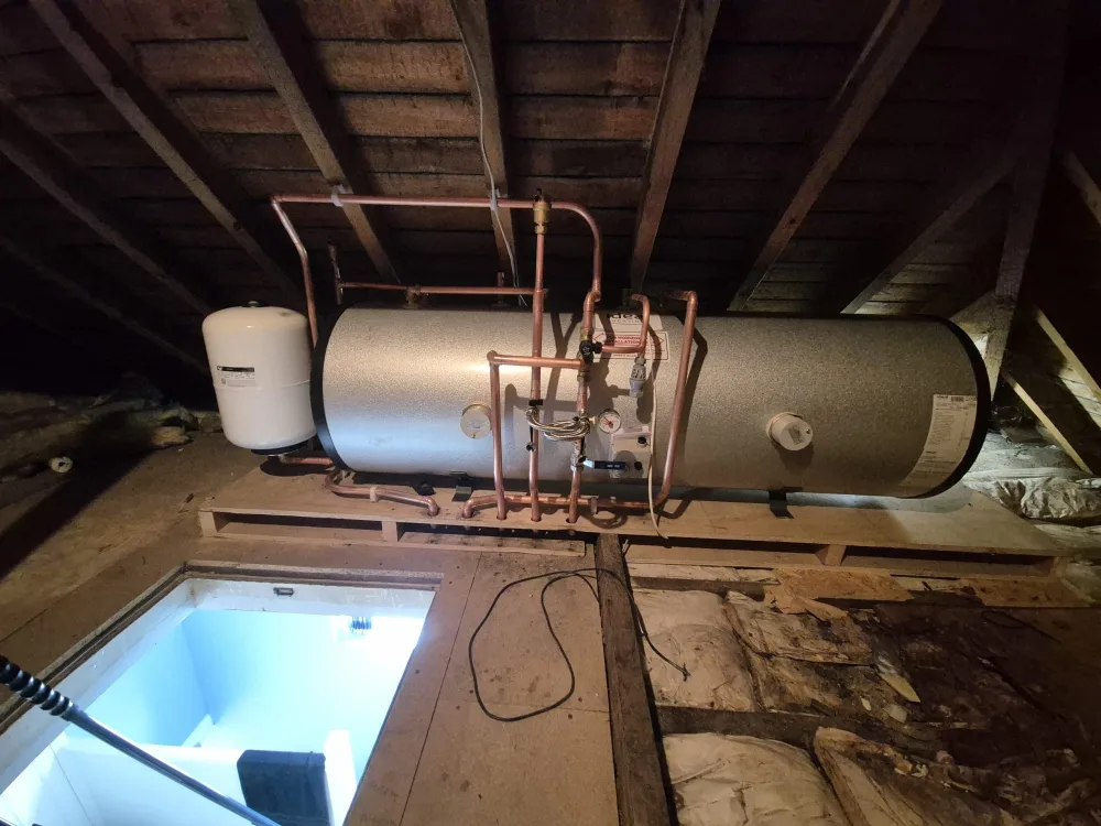 Large hot water cylinder with copper pipework in a plant room