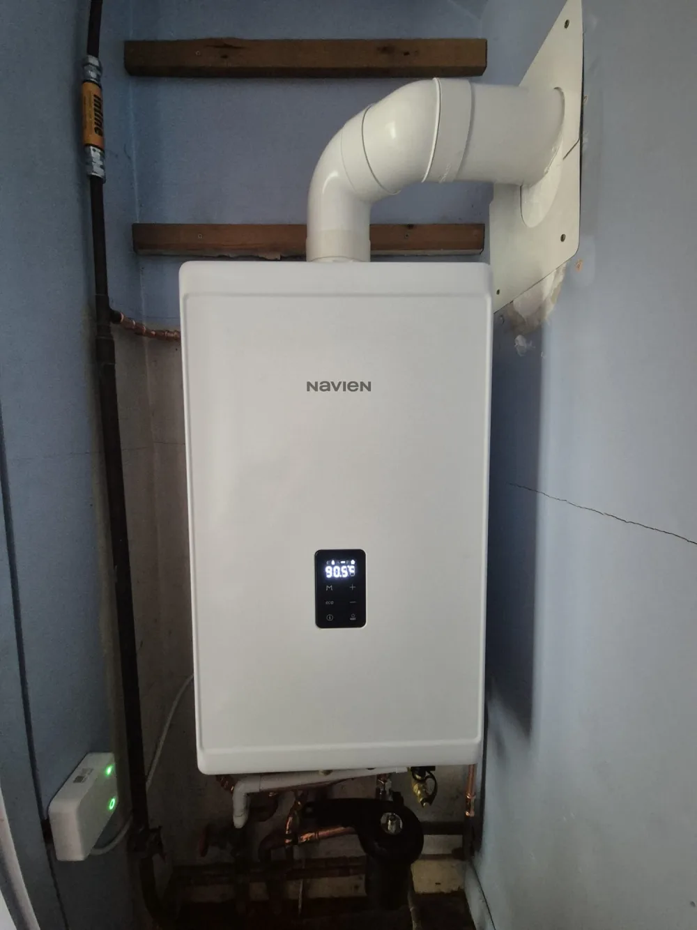 Compact wall-mounted domestic boiler with white flue pipe