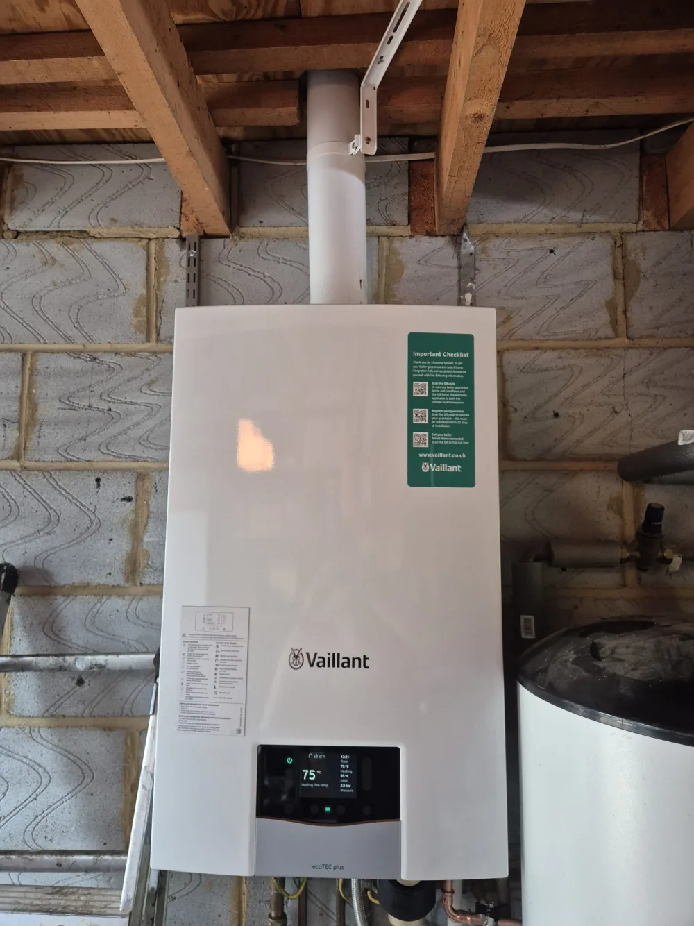Wall-mounted domestic boiler inside a narrow utility cupboard