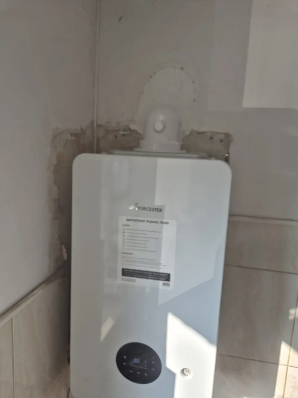 Wall-mounted domestic boiler with exposed pipework below